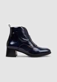 Bottines en cuir verni bleu marine avec un talon épais, bout arrondi, fermeture éclair à l'avant et coutures décoratives sur les côtés.