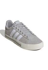 Baskets en suède gris avec des rayures blanches en cuir, bout rond, design à lacets et semelle en caoutchouc texturée. Logo sur le talon et sur la languette.