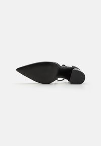 Black high-heeled shoe with a pointed toe, smooth texture, and a solid rubber sole featuring subtle ribbing for grip.