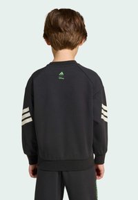 Čierna mikina s kapucňou so zeleným logom Adidas pri krku a tromi bielymi prúžkami na každom rukáve. Hladká textúra, uvoľnený strih, rebrované manžety.