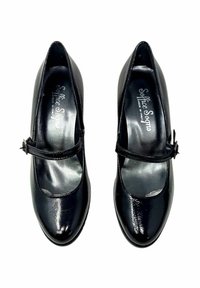Scarpe Mary Jane in vernice nera con punta arrotondata, una sola fascetta sul collo del piede e un tacco a blocco basso. Finitura lucida e strutturata.