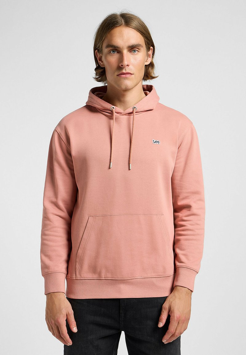 Felpa rosa in cotone morbido, dotata di una tasca frontale con patta, polsini a coste e cappuccio con coulisse. Piccolo logo "Lee" sul petto.