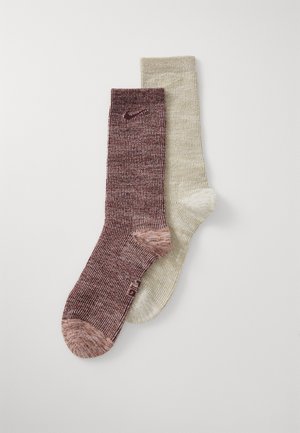 Two pairs of crew socks: one maroon with a ribbed texture and pink accents, the other light beige with a subtle pattern.