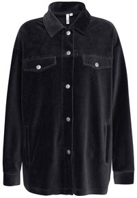 Chaqueta de pana negra con cuello, botones a presión, dos bolsillos en el pecho y bolsillos laterales. Presenta un ajuste relajado y una textura acanalada.