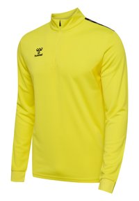 Gelber langärmeliger Sportpullover mit einem Reißverschluss-Kragen; verfügt über schwarze Akzente und einen strukturierten Stoff. Logo befindet sich auf der Brust.