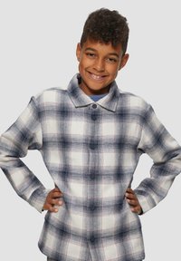 Karierte Hemd in Weiß mit Marineblau- und Rottönen, mit Kragen, großen schwarzen Knöpfen und einem lässigen Schnitt. Weiches, strukturiertes Material.