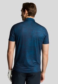 Polo shirt a maniche corte di colore blu navy con un sottile motivo testurizzato. Il materiale sembra liscio. Il colletto e le cuciture sono adattati per una vestibilità perfetta.