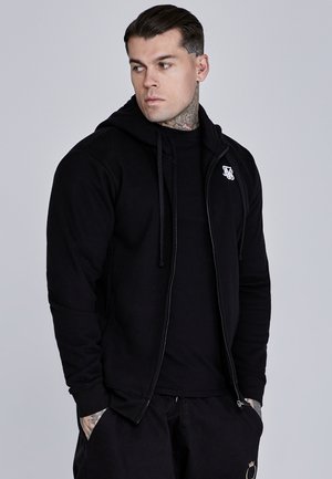 Schwarze Zip-Hoodie mit Kordelzügen, aus weichem Stoff gefertigt. Verfügt über ein kleines Logo auf der Brust und gerippte Bündchen für einen enganliegenden Look.