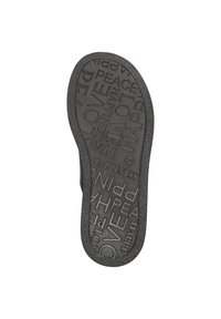 Schwarze Gummisohle mit eingeprägtem Text, der Wörter wie "LIEBE", "FRIEDEN" und "GLÜCK" enthält. Texturierte Oberfläche für besseren Halt.