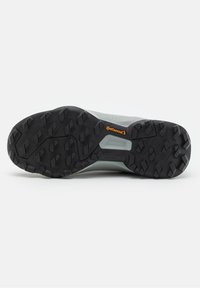 Semelle de chaussure avec des crampons noirs profonds et le logo Continental, conçue pour la traction et la durabilité sur des surfaces accidentées.