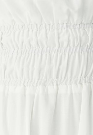 Tissu blanc avec des bandes élastiques smockées horizontales créant une texture froncée rassemblée en rangées alternées lisses et très froncées.