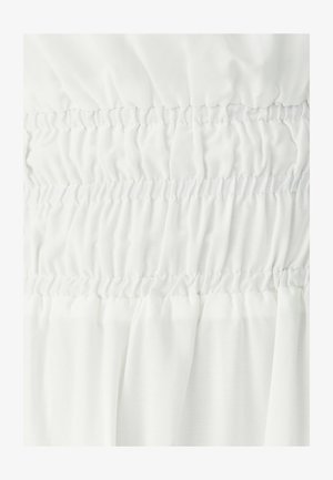 Tissu blanc avec des bandes élastiques smockées horizontales créant une texture froncée rassemblée en rangées alternées lisses et très froncées.