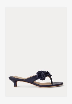 Sandálik na podpätku typu kitten z tmavomodrej kože s otvorenou špičkou, remienkom medzi prstami a dvoma ozdobnými aplikáciami kvetov na vrchu.
