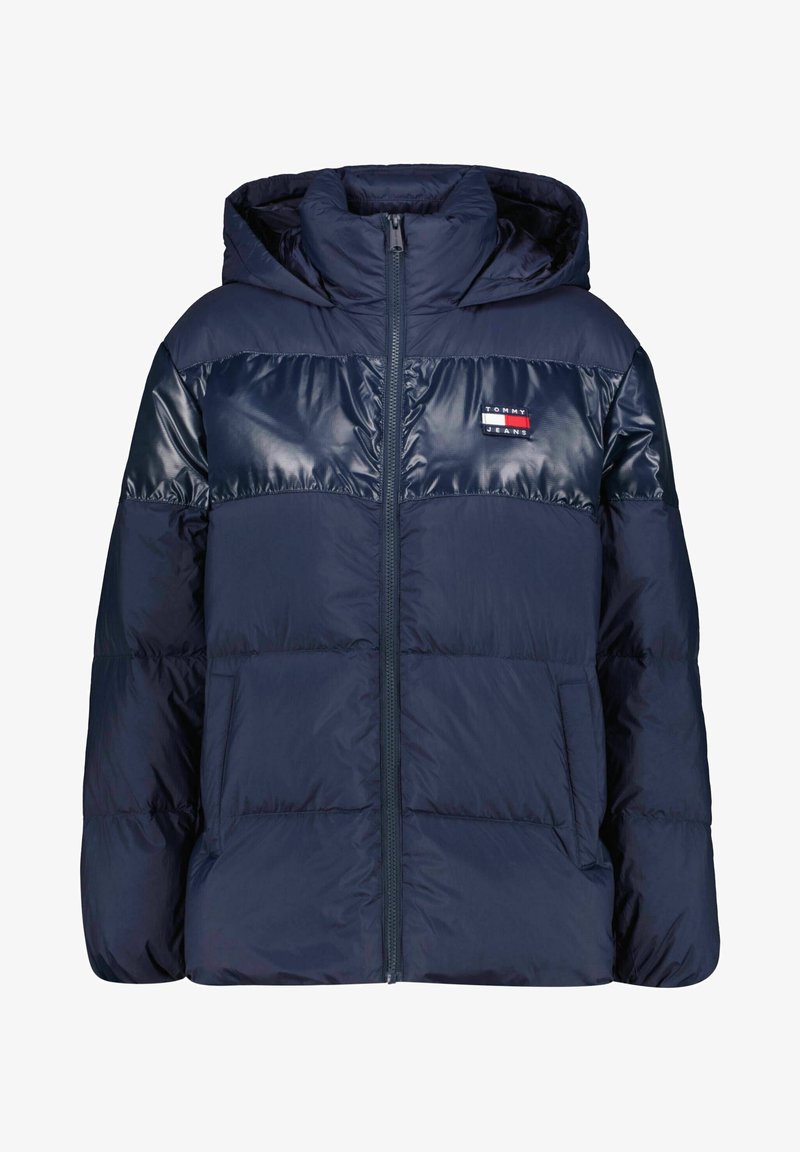 Veste matelassée bleu marine avec capuche, fermeture éclair intégrale, deux poches avant, et un patch logo Tommy Jeans sur la poitrine.