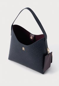 Morska torebka skórzana o fakturze, w zaokrąglonym kształcie, ze złotymi akcentami i wnętrzem w kolorze bordowym. Zawiera odpinany, ciemno-bordowy metek.