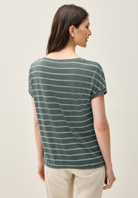 Camiseta de manga corta verde a rayas con un ajuste relajado, cuello redondo y textura suave; rayas horizontales blancas en la parte posterior.