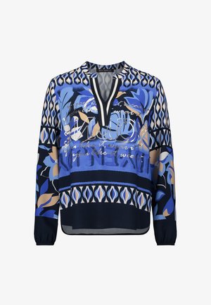 Blouse à motifs bleus à manches longues, avec des dessins floraux en bleu, crème et marine, un décolleté en V profond et une texture de tissu douce.