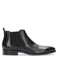 Botas Chelsea de cuero negro con paneles elásticos en los laterales, punta redonda y un tacón bajo apilado. El diseño incluye una lengüeta en el talón.