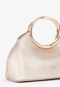 Bolso de mano en un tono dorado rosa metálico con una textura suave, asa redonda de anillo dorado y una base plana. Presenta un detalle de logo embosado.
