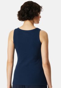 Navyblauwe tanktop van soepel stof, met een ronde halslijn en zonder mouwen. Subtiele ribbelstructuur met een fitted silhouet.