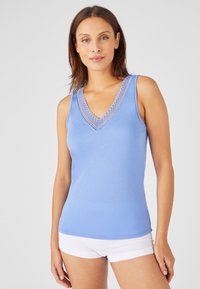 Top sottile azzurro chiaro con scollatura a V e dettagli in pizzo. Realizzato in tessuto morbido, ha un design aderente e senza maniche.