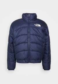 Doudoune bleu marine avec un col montant, fermeture éclair, poignets élastiques et un logo blanc en haut à gauche. Détails de coutures verticales.