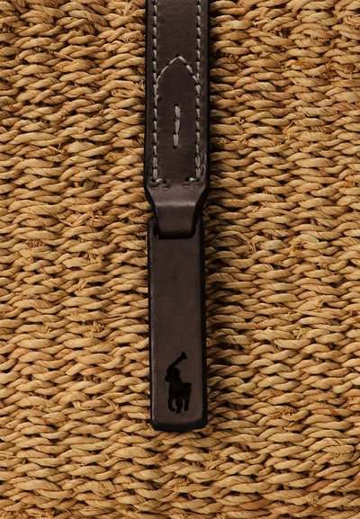 Donkerbruine leren riemuiteinde met gestikte details en een zwart polo speler logo op een geweven stro achtergrond.