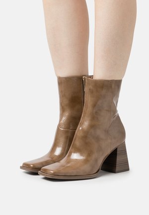 Braune, glänzende Lederstiefeletten mit quadratischer Zehenform und blockartigem Holzabsatz, ausgestattet mit einem seitlichen Reißverschluss.