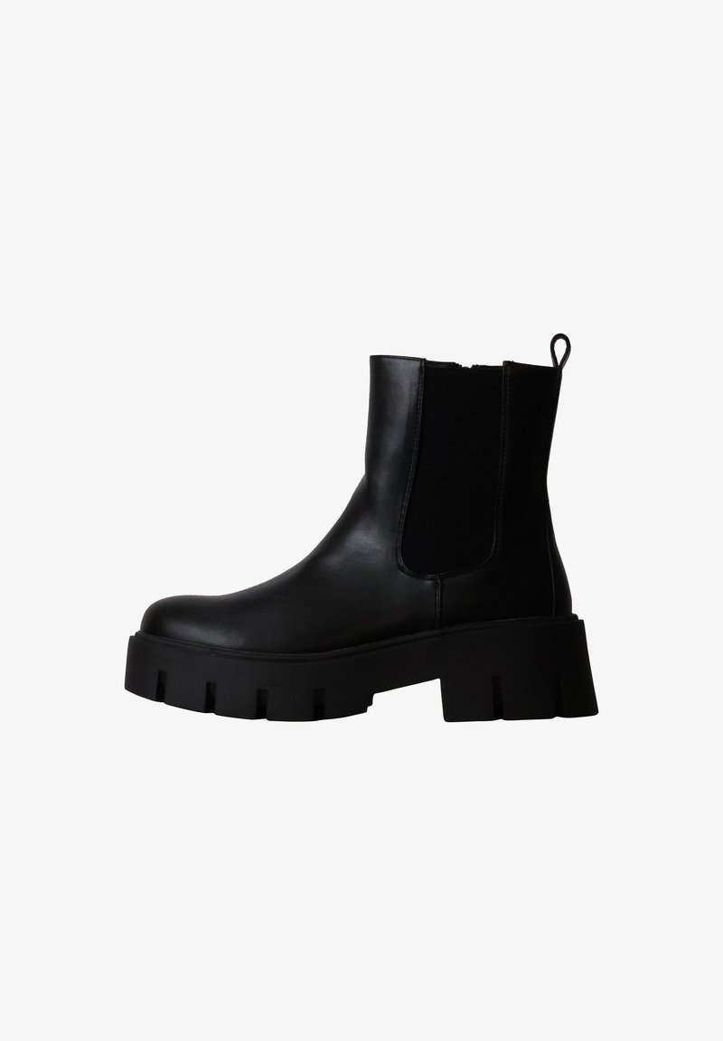 Bottine noire en cuir avec semelle épaisse, panneau élastique sur le côté et languette à l'arrière.