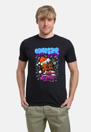 Sort bomulds T-shirt med et livligt grafisk print af en tegneseriefigur med en boombox og stiliseret tekst "Gangster Wrappers" i lilla og blå.