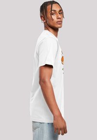 White cotton t-shirt featuring a colorful cartoon graphic on the front. Short sleeves and a classic crew neck design.