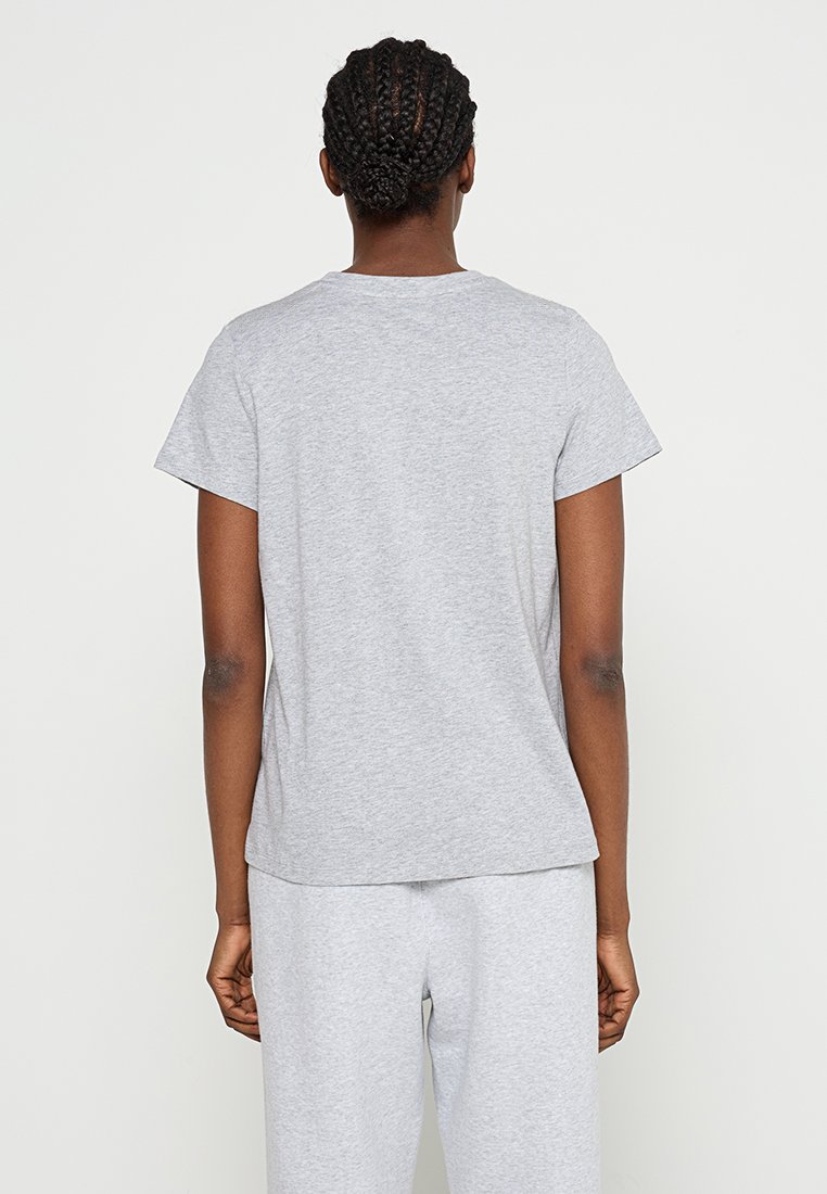 Szara bawełniana koszulka z krótkimi rękawami i okrągłym dekoltem. Prosty design z prostym krojem, noszona z pasującymi szarymi spodniami.