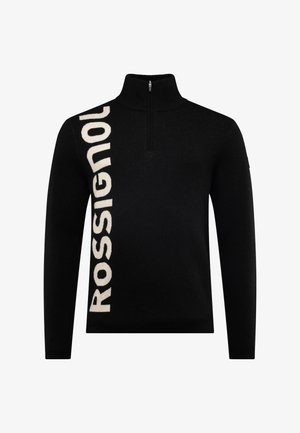 Sort strikket sweater med en kvart lynlås krave, med stor hvid "ROSSIGNOL" tekst på venstre side og en glat overflade.