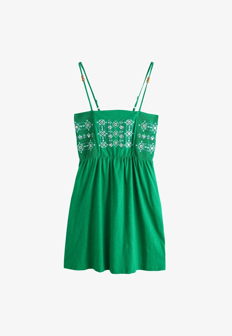 Robe verte sans manches avec fines bretelles, ornée de broderies géométriques blanches et d'embellissements argentés sur le corsage ajusté.