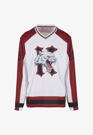 Maillot de hockey blanc avec des manches maroon, des rayures noires et maroon, une tête de tigre blanc rugissante et une lettre "K" stylisée en noir sur le devant.