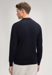 Marineblauer Pullover mit langen Ärmeln, gerippten Bündchen und Saum, glatter Textur und klassischem Kragendesign.