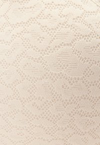 Helles beige Spitzenmaterial mit einem gewellten Muster, das aufwendige Durchbrüche und feine, detaillierte Texturen aufweist.