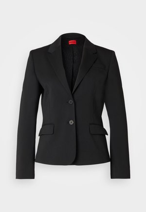 Blazer noir en tissu lisse, avec un col cranté, deux poches avant et une fermeture à deux boutons. Intérieur doublé avec un motif de logo.