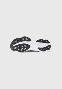 Semelle de chaussure de sport, avec une semelle extérieure en caoutchouc noir à motifs striés, et une semelle intermédiaire blanche pour l'amorti. Conçue pour une traction et un soutien optimaux.