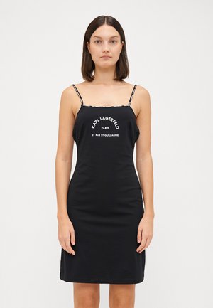 Black fitted dress with thin spaghetti straps. Features white logo print on the front. Made from smooth fabric with a straightforward design.