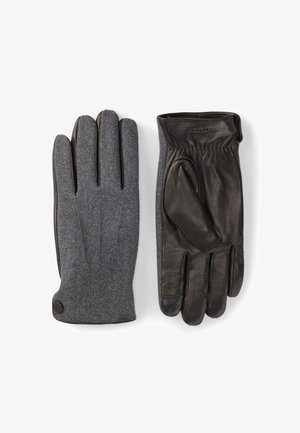 Leder- und graue Filzhandschuhe. Der linke Handschuh hat eine graue Filzaußenseite, während der rechte hauptsächlich aus schwarzem Leder mit einer strukturierten Handfläche besteht.