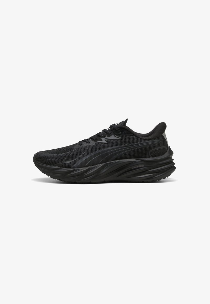 Baskets noires de sport avec une tige texturée, une semelle incurvée et un talon renforcé. Elles présentent des lacets et un élément de design subtil sur le côté.