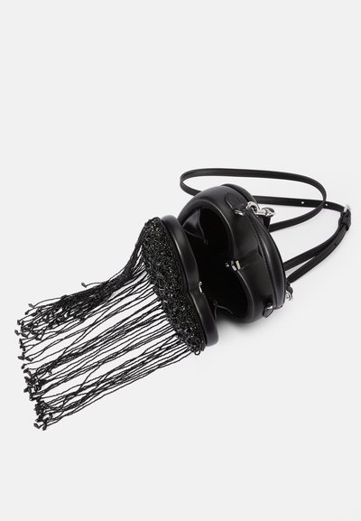 Μαύρη δερμάτινη τσάντα ώμου με στρογγυλή σιλουέτα, με λεπτομέρεια φούντας από χάντρες στο κάτω μέρος και αποσπώμενο λουρί για ευελιξία.