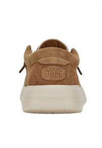 Sneaker in suede marrone con suola in gomma beige e dettagli del logo sul tallone. Presenta un design a taglio basso e linguette laterali per facilitare l'indossamento.
