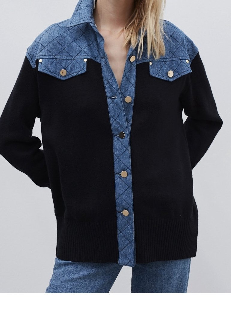 Svart stickad tröja med en denimbeklädd yoke, med knäppning framtill och två bröstfickor med metallackenter.