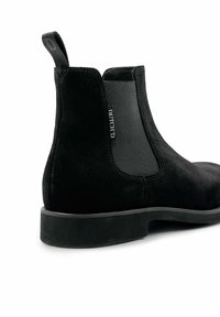 Zwarte suède Chelsea boots met elastische zijkanten, versterkte hieltab en een platte rubberen zool. Minimale stiksels en een gladde textuur.