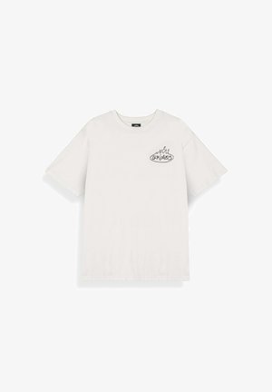 Biały T-shirt z krótkim rękawem z małą czarną grafiką płomienia i napisem "GRIMEY" na lewej stronie klatki piersiowej.