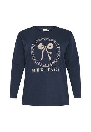 Navy long-sleeve t-shirt in soft cotton, featuring a cream bow graphic and circular text design that reads "HERITAGE" at the bottom.