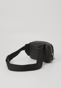 Schwarze Leder-Crossbody-Tasche mit rechteckiger Form, Reißverschluss, strukturiertem Oberflächenmaterial und verstellbarem Stoffriemen.
