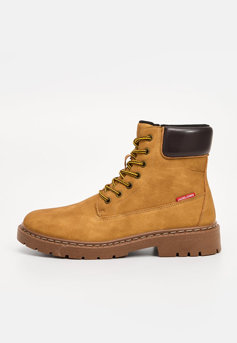 Schnürstiefelette aus braunem Wildleder mit einem glatten Kragen aus braunem Leder, gelben Schnürsenkeln und einer robusten braunen Außensohle mit Traktionsrillen.